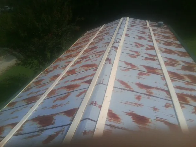 Rusted metal roof panels with new wood purlins before replacement — Storm Damage Roof Repair in Livermore Falls by Roofing Brothers